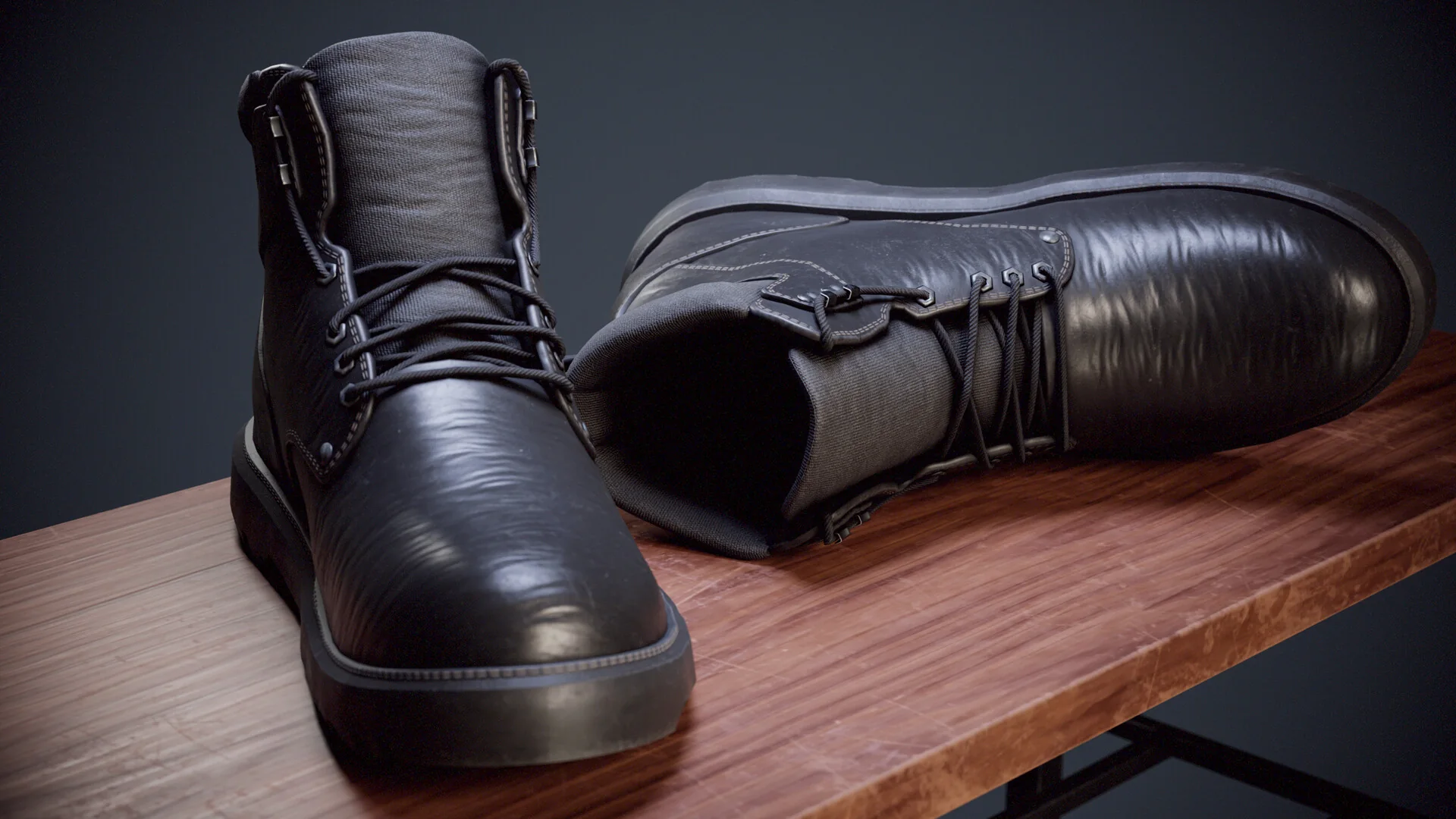 Two black leather boots on a wooden table, one upright and one lying on its side, lit from the left.