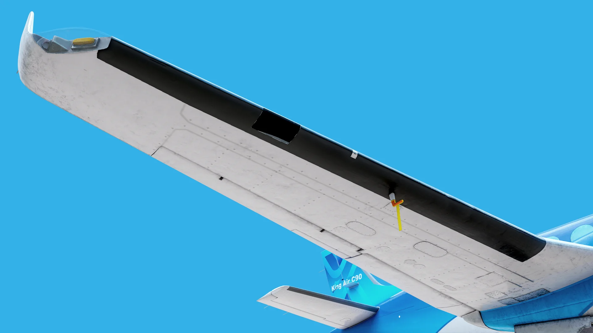 Underside of the right wing showing the black de-icing boot along the leading edge, the stall warning vane and the wingtip light.