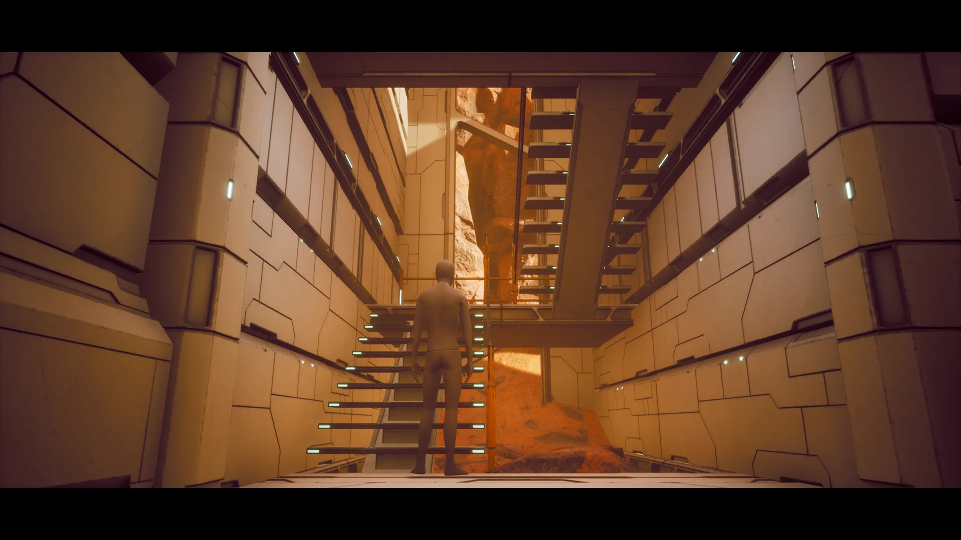 Figure standing at the foot of a stairwell that climbs toward an opening in the canyon wall.